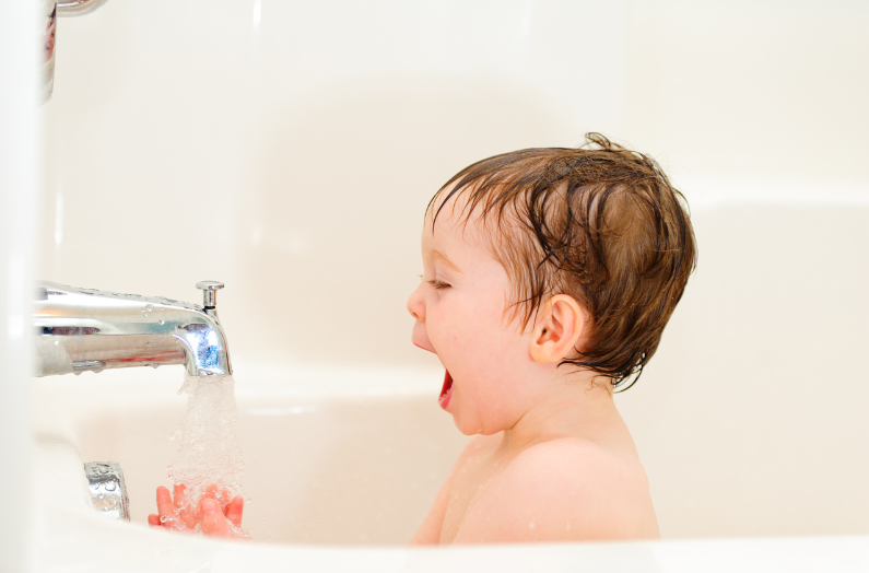 Child in bath splashing water