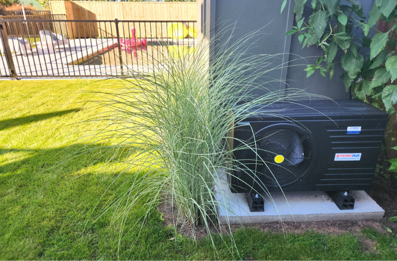 A hot water heat pump system installed in someone's back yard to heat their pool